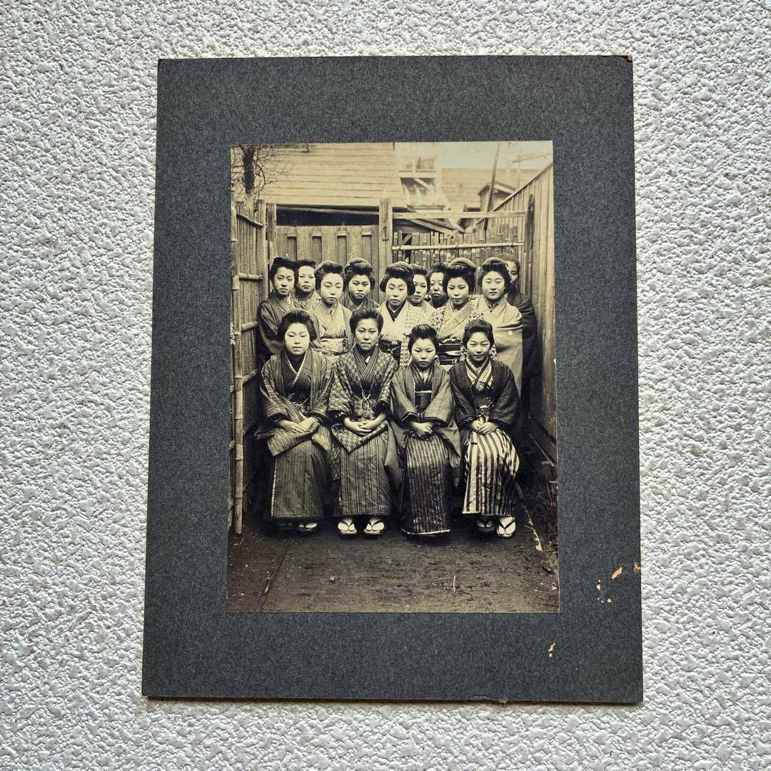 Mounted antique photograph showing a posed group of Japanese women wearing kimonos.