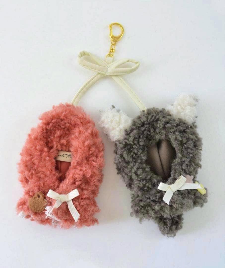 Two fluffy doll poncho keychain covers, one pinkish-red and one gray, each with a small bow and a gold clasp on a white background.