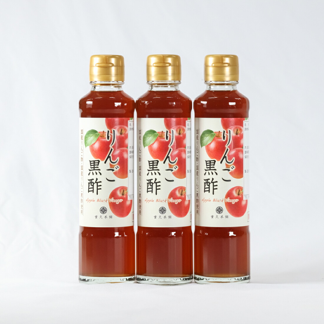 Three 185ml bottles of apple black vinegar (りんご黒酢) standing side by side with labels visible.