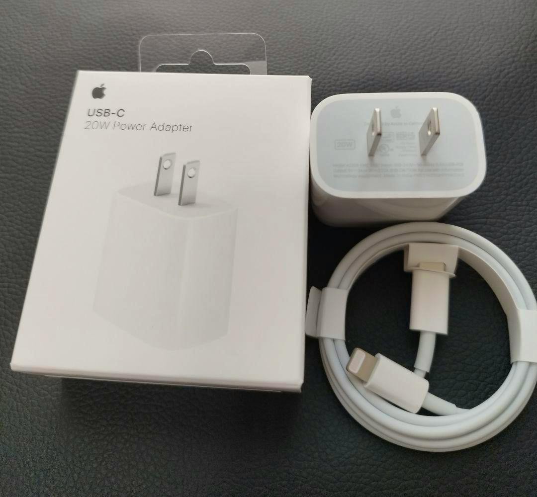 Apple 20W USB‑C power adapter, coiled USB‑C to Lightning 1m cable, and product box on a dark surface.