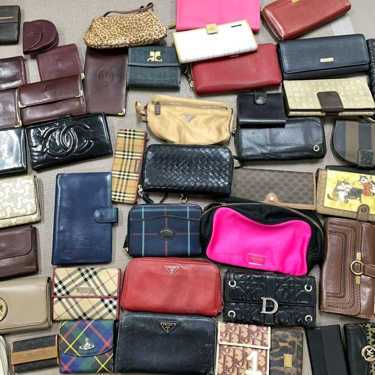 Multiple branded wallets and small leather goods arranged flat on a surface.