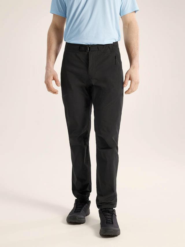 Front view of a model wearing the men's black Gamma SL polyester pants.