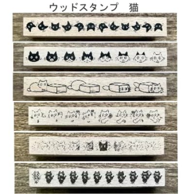 Multiple wooden stamps with various cat-face and cat-scene designs shown in horizontal rows on a wood background.