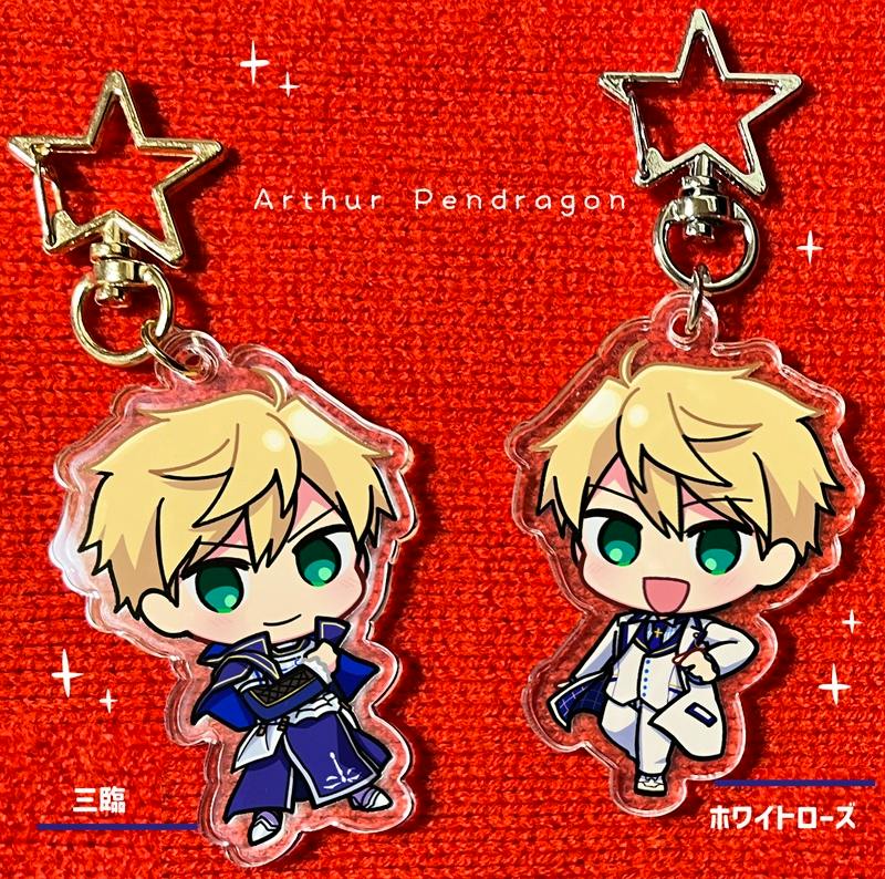 Two acrylic Arthur keychains with star-shaped metal key rings displayed on a red background.