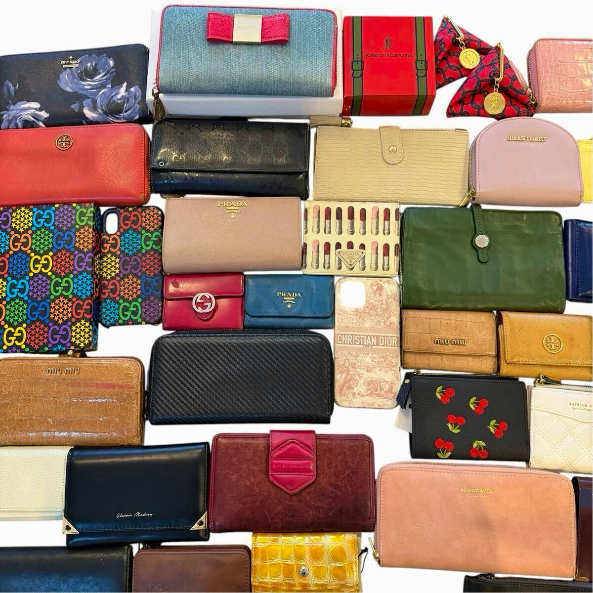 Flat-lay of many wallets, coin purses, and small bags arranged together showing an assorted branded lot.
