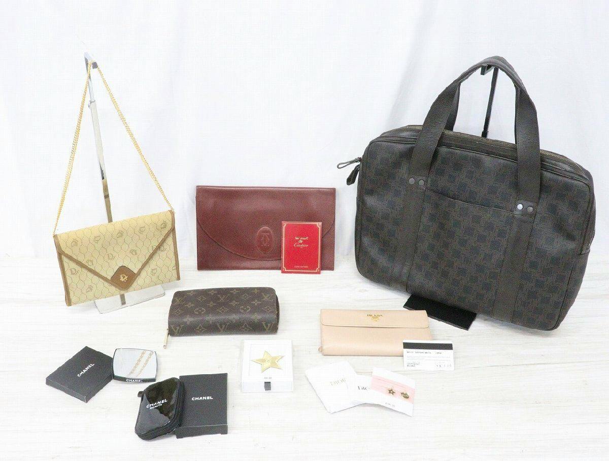 Assorted branded bags, wallets, and small accessories arranged on a white surface.