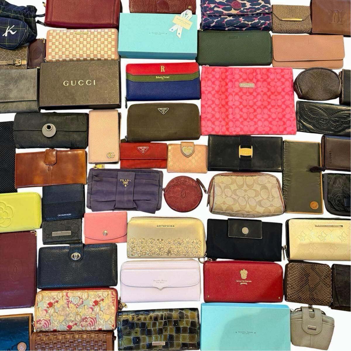 Flat lay of many assorted wallets and small leather goods from various brands arranged on a white background.
