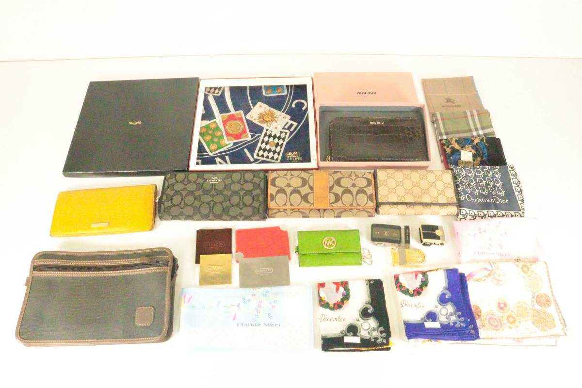 Flat lay of assorted wallets, small pouches, boxes, and fabric handkerchiefs arranged on a white surface.