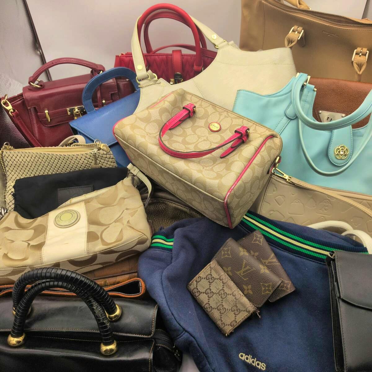 Pile of assorted bags and small handbags displayed together.