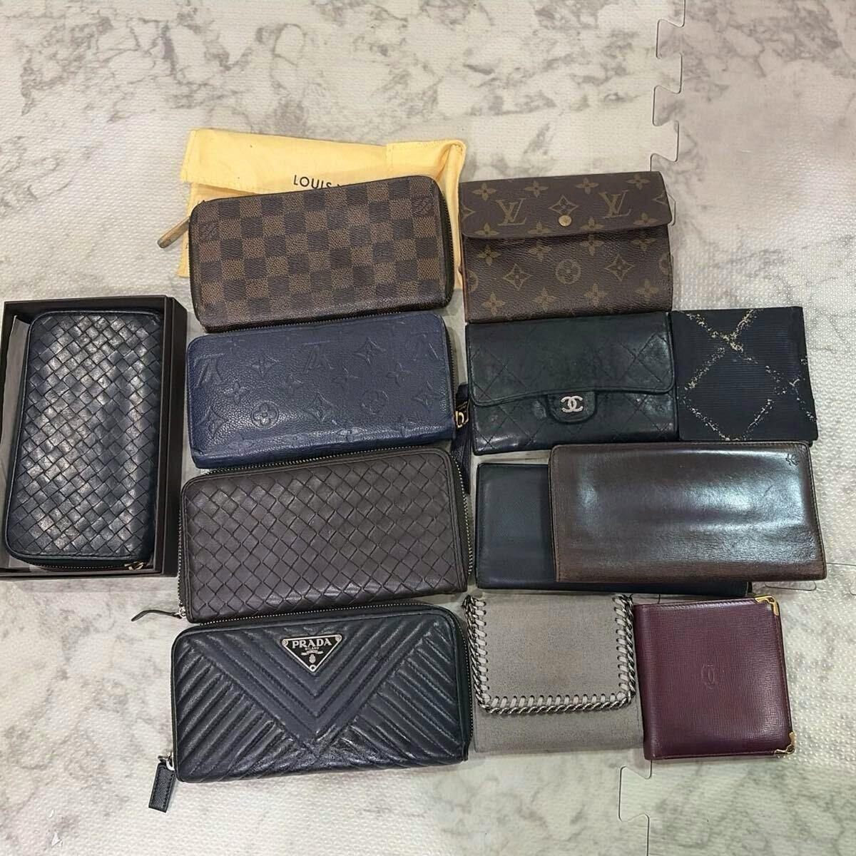 Several assorted wallets and long wallets arranged on a light surface showing various brand patterns and logos including Louis Vuitton and Prada.