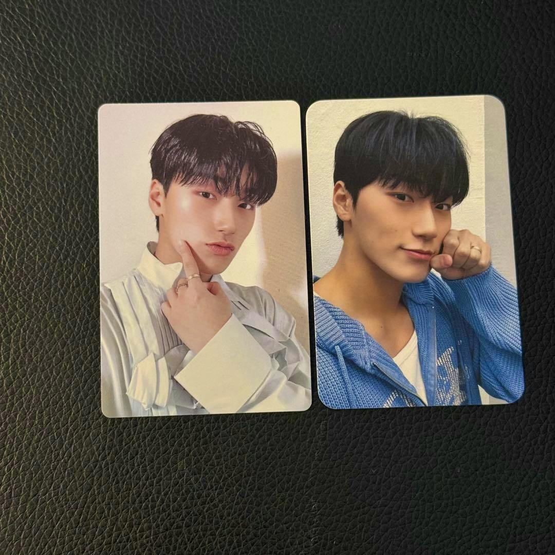 Two ATEEZ photocard portrait photos placed side by side on a black textured surface.