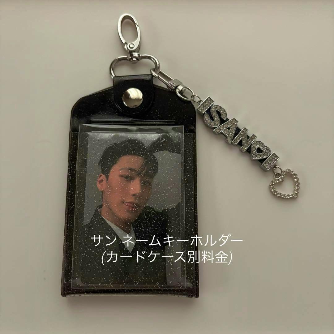 The ateez サン ネームキーホルダー bag charm attached to a glittery black card case with a photo card visible.