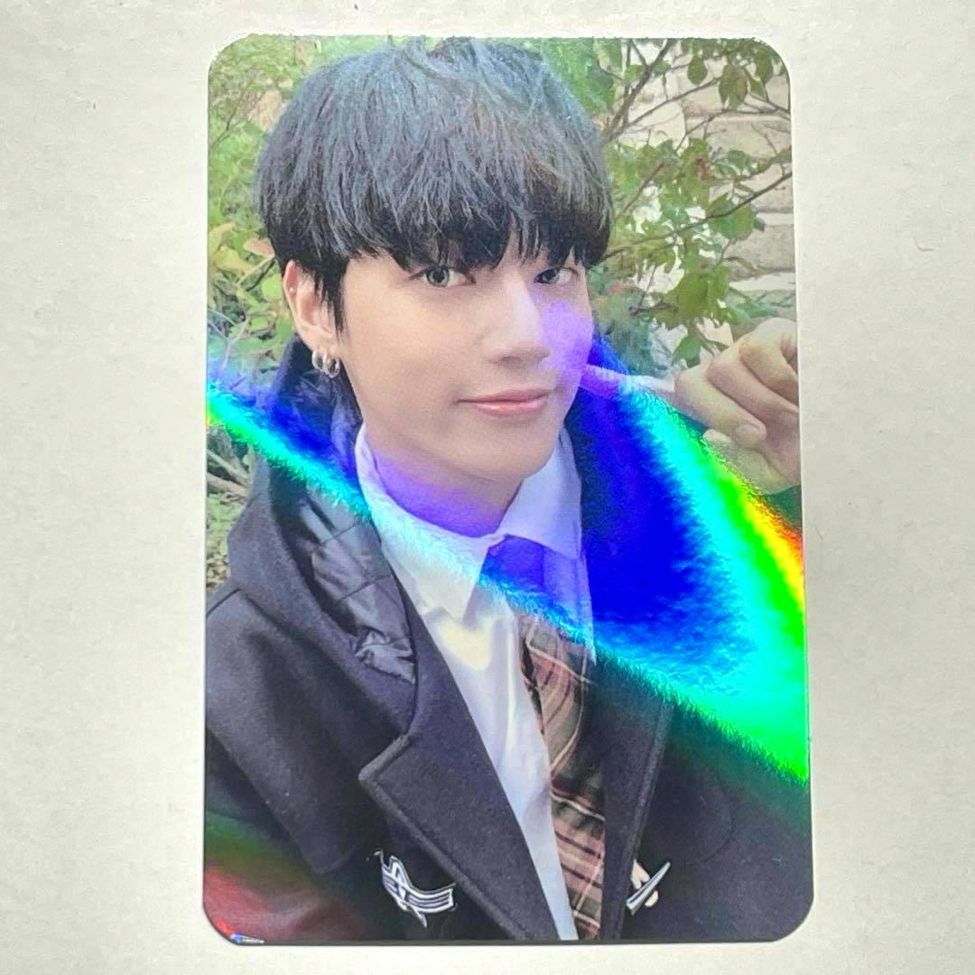 Photocard showing a K-pop idol wearing a blazer and tie with a holographic rainbow reflection across the card.