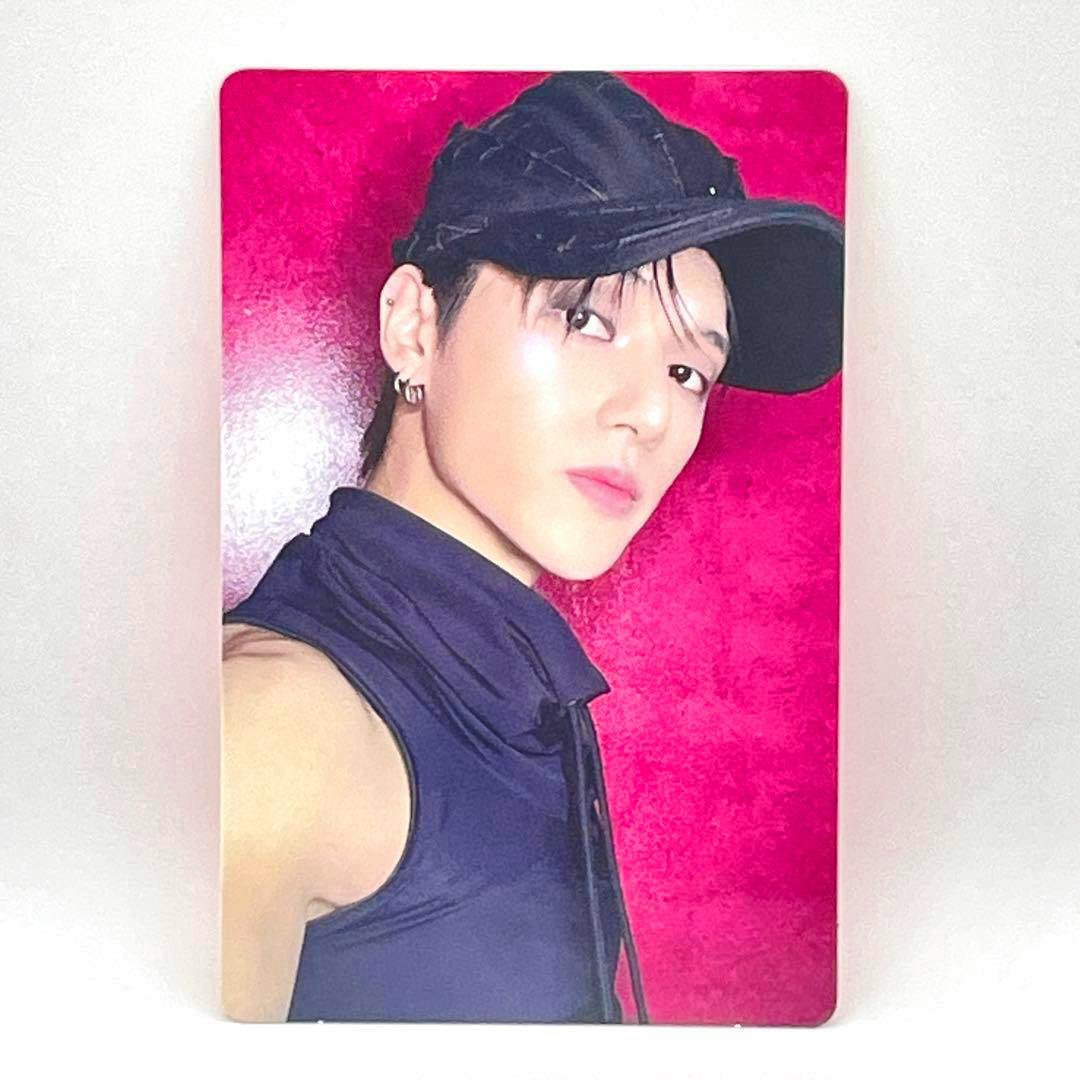 Photocard of ATEEZ ウヨン (Wooyoung) wearing a black cap and sleeveless top against a red background.