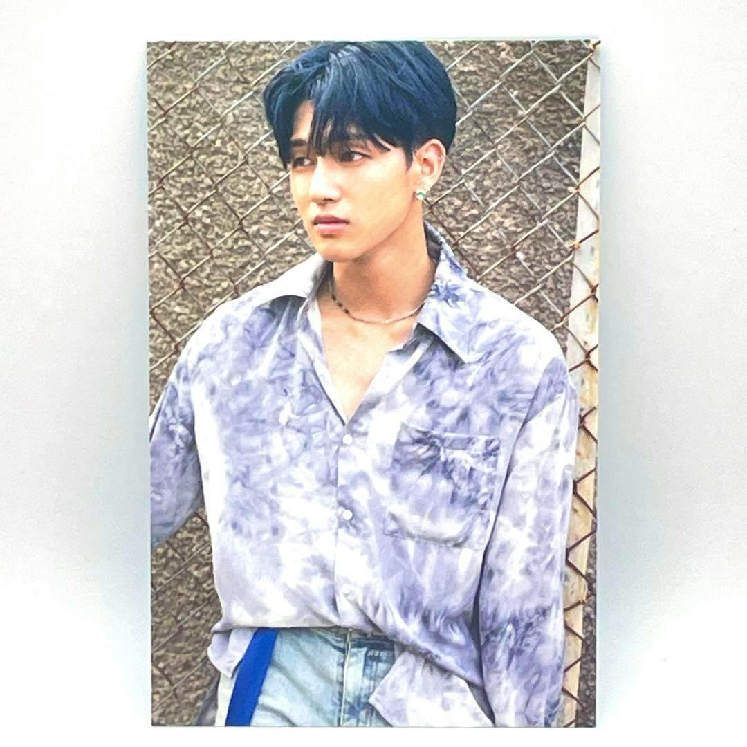 Photocard of ATEEZ member Wooyoung wearing a light purple tie-dye shirt posed in front of a chain-link fence.