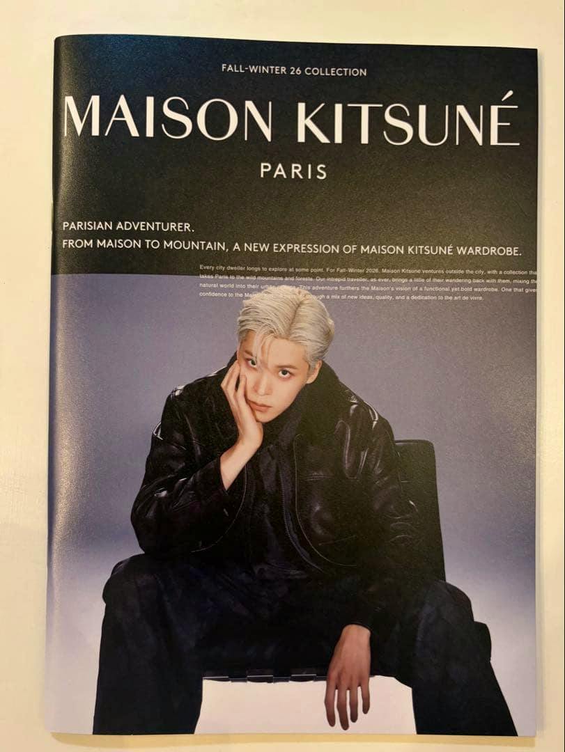 Photograph of the MAISON KITSUNÉ pamphlet cover showing the brand title and a seated model wearing a black leather jacket.