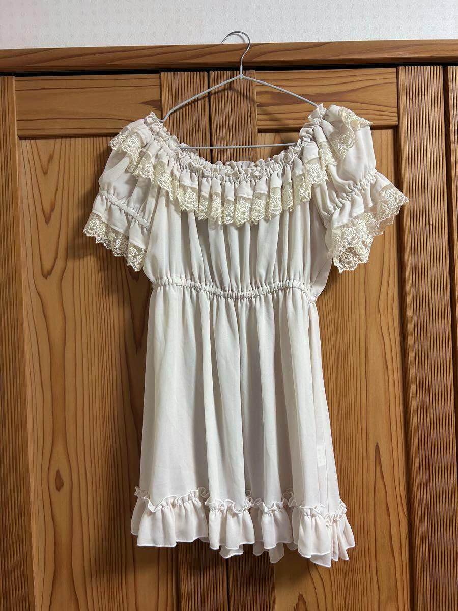 Ivory ATELIER PIERROT puff-sleeve shirring women's blouse hanging on a hanger against wooden doors.