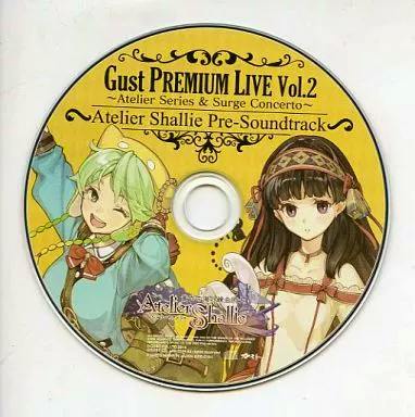 Photo of the CD disc for Gust PREMIUM LIVE Vol.2 — Atelier Shallie Pre-Soundtrack showing disc artwork with two characters and title text.