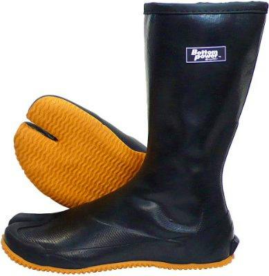 Pair of Atom Tabi BP471 Large split-toe black rubber boots with orange soles, one upright and one showing the sole.