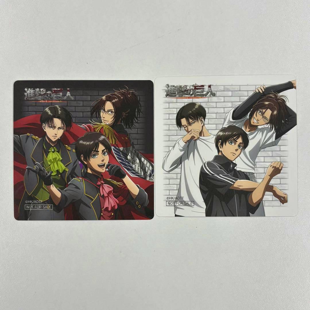 Two square coasters featuring illustrated designs of Eren, Levi, and Hange from Attack on Titan shown side by side on a white surface.