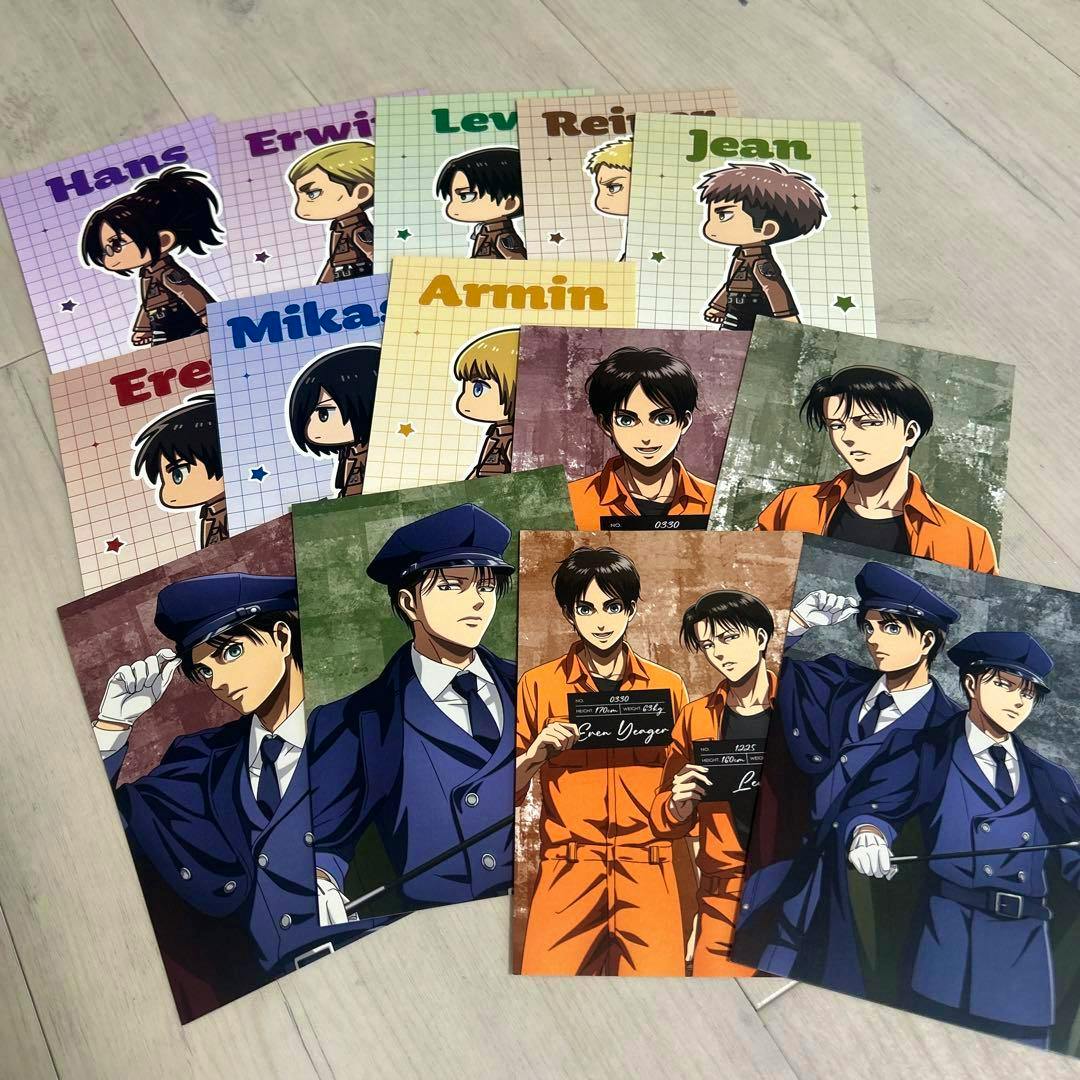 Photo of the Attack on Titan "guard and prisoner" special postcard full set laid out, showing chibi walking designs and full-color character portraits.
