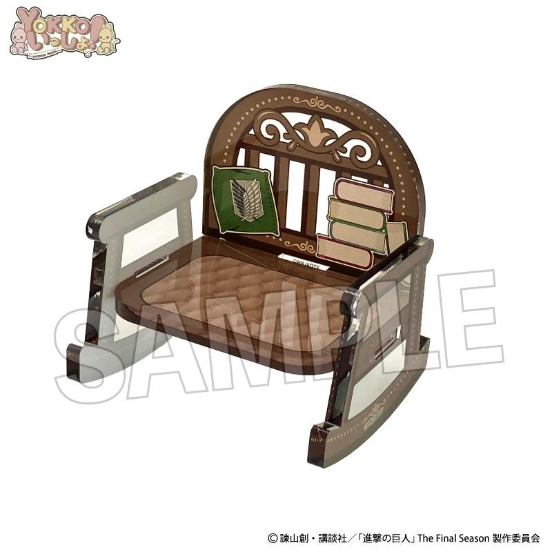Brown plastic mini rocking chair with ornate backrest and printed book and emblem decorations.