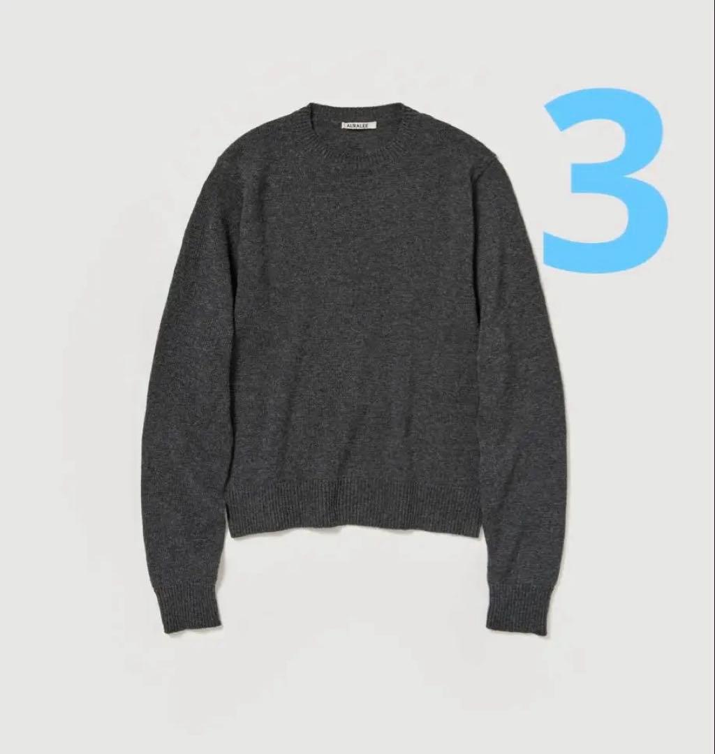 Dark gray cashmere crewneck sweater laid flat on a white background.