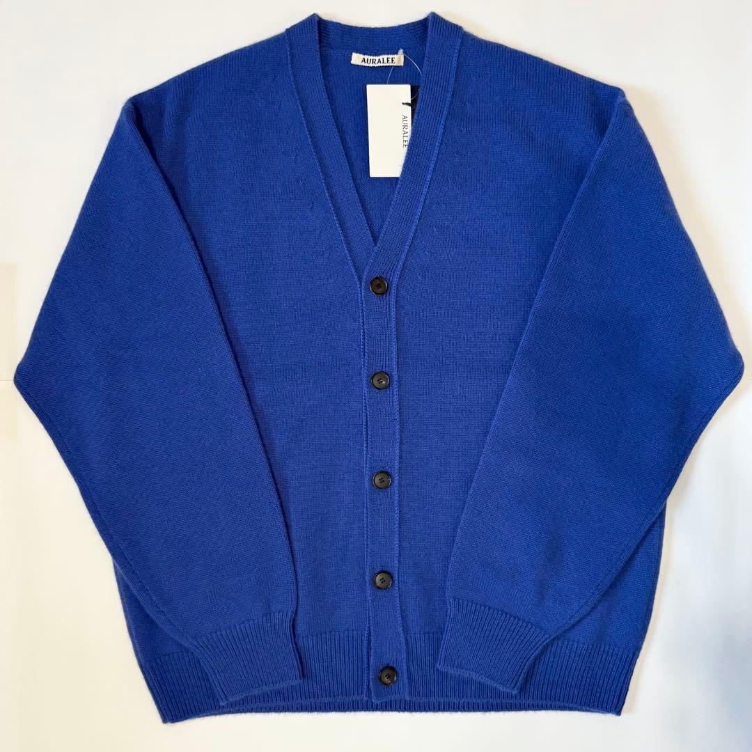 Blue AURALEE baby cashmere knit cardigan laid flat showing the front with a V-neck and buttons.