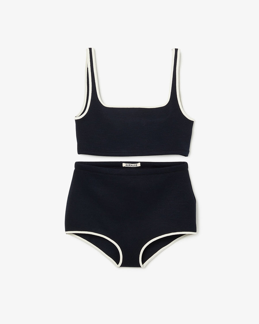Flat-lay of the swim set showing a black crop tank top and matching high-waist briefs with white trim.