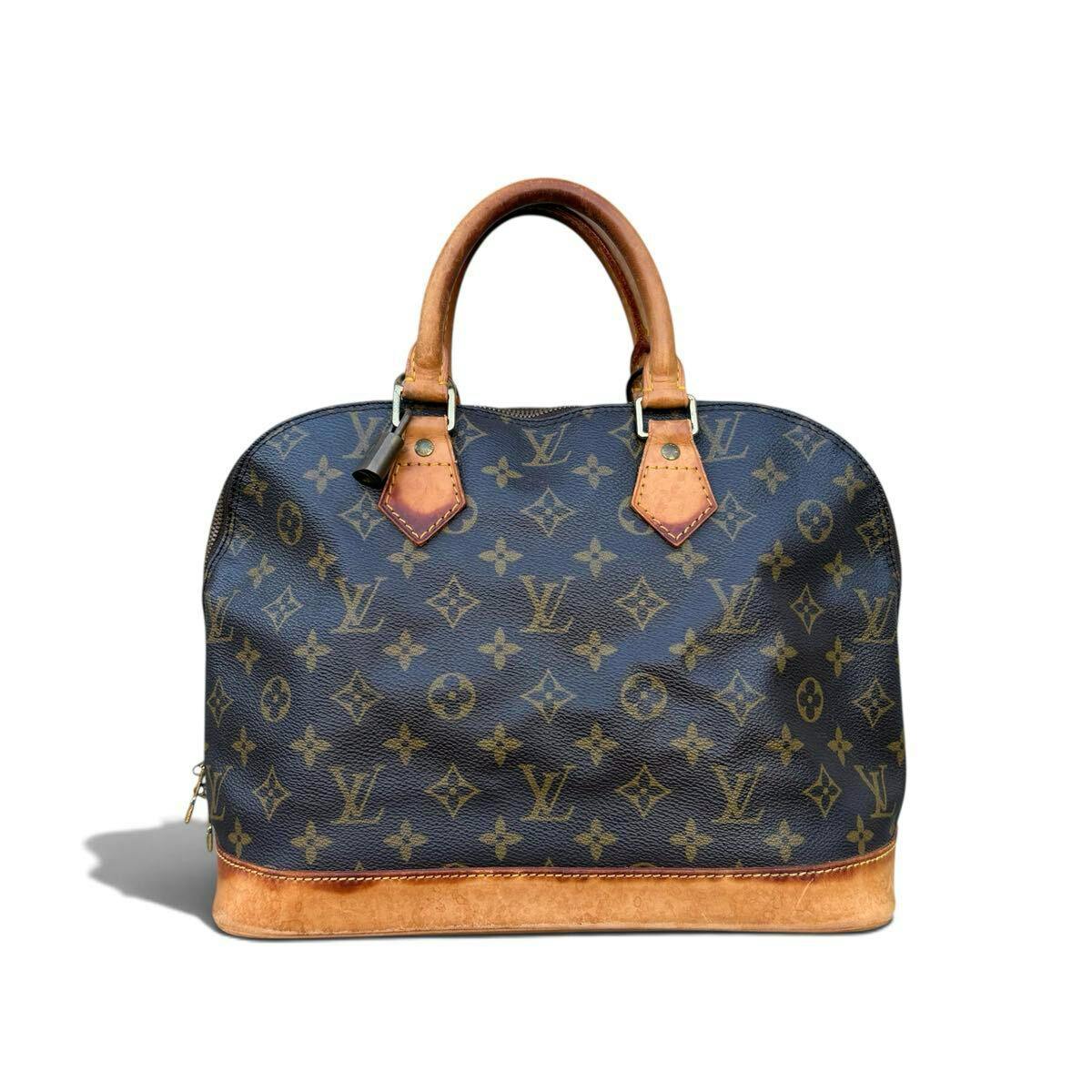 Front view of the Louis Vuitton Alma monogram brown handbag with leather handles and vachetta trim on a white background.