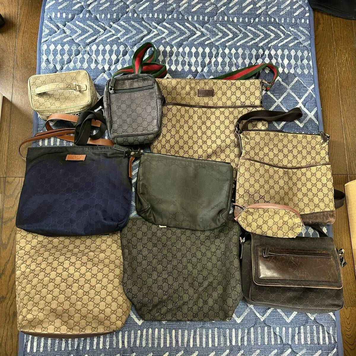 Top-down photo of the ten-item set of GUCCI GG canvas and leather bags arranged on a rug, showing various totes and shoulder bags.