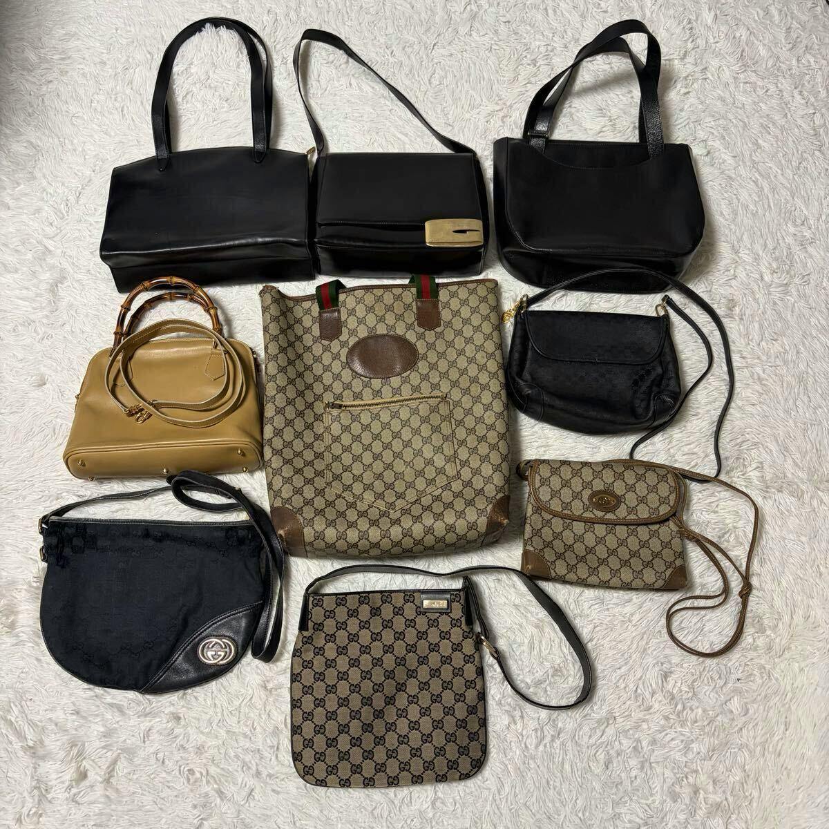 Nine GUCCI bags, including GG canvas totes and shoulder bags, arranged on a white rug.