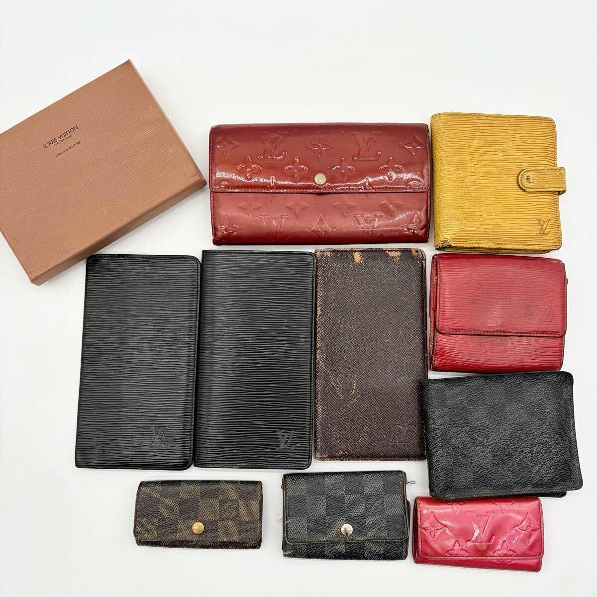 Multiple Louis Vuitton wallets and a Louis Vuitton box arranged on a white background.