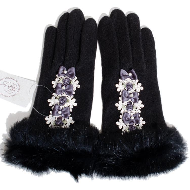 Pair of black gloves with ribbon rose embellishments and faux fur cuffs shown flat.