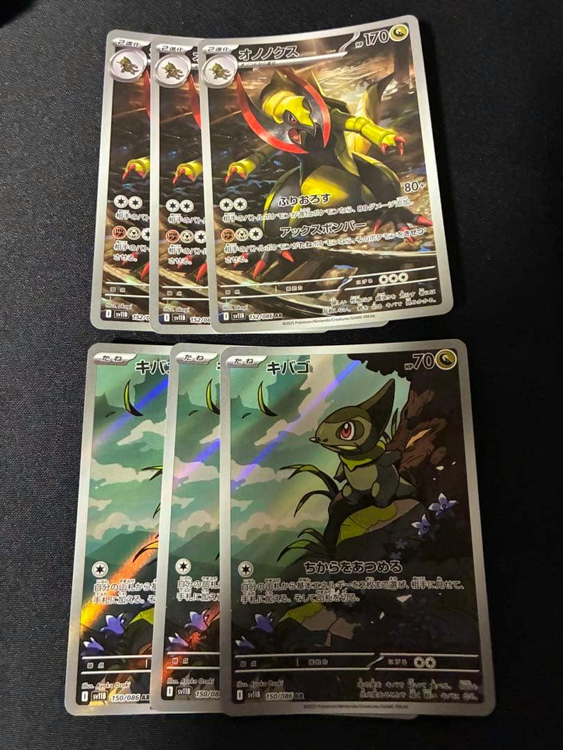 Six trading cards on a dark surface: three オノノクスAR cards at the top and three キバゴAR cards at the bottom.