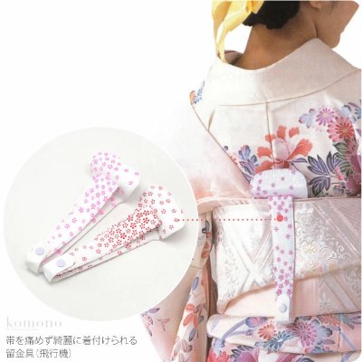 Back view of a woman wearing a kimono showing a floral-patterned obi clip, with a close-up inset of the clips.