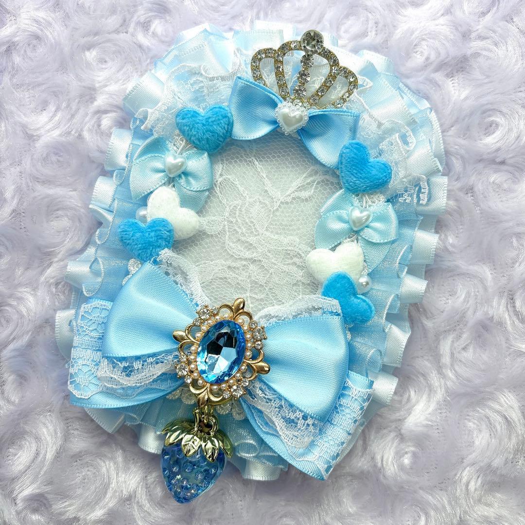 Light blue lace-decorated card case with ribbon bows, felt hearts, a crown ornament, and a blue gem strawberry charm.