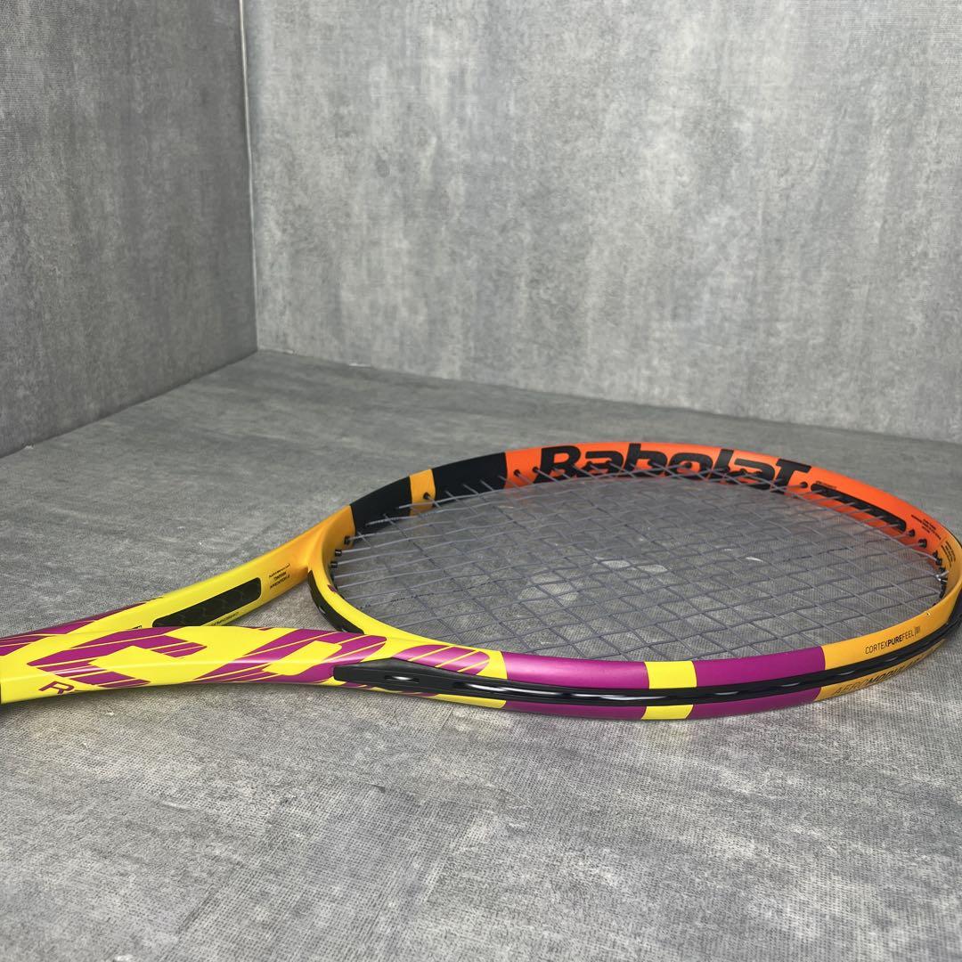 Babolat PURE AERO RaFa tennis racket laid flat on a gray surface, full frame visible.