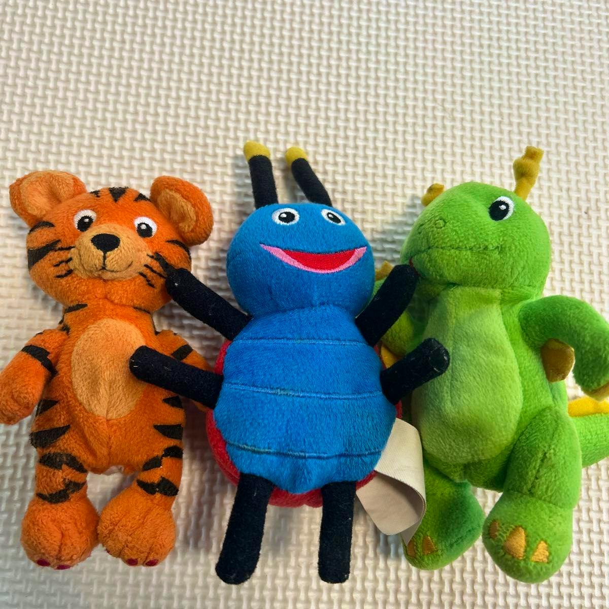 Three plush toys (a tiger, a ladybug, and a dragon) shown side by side on a textured white background.