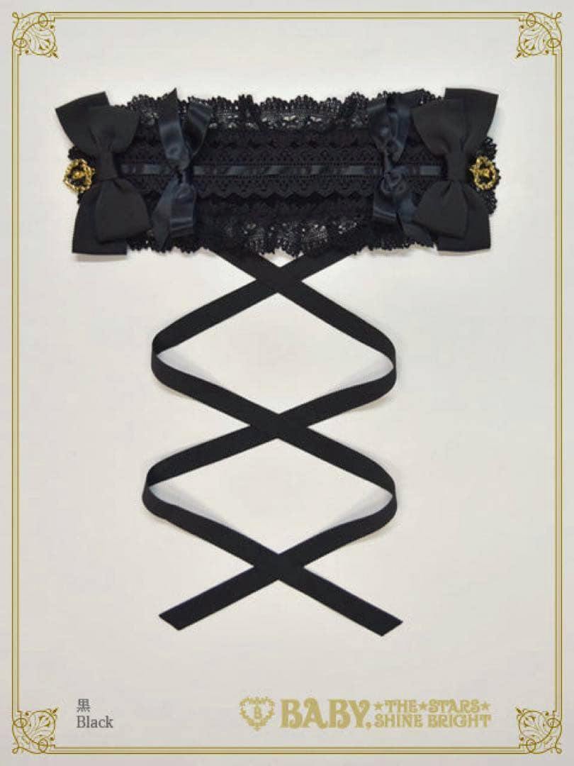 A black lace headdress with ribbon bows and long crisscrossed hanging ribbons displayed on a white background.