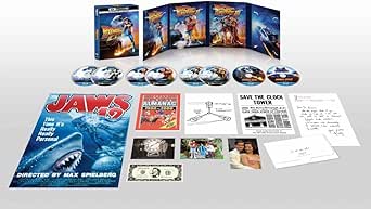 Laid-out product photo of the Back to the Future Trilogy 40th Anniversary Deluxe Edition 4K UHD + Blu-ray set showing opened cases, discs, and included inserts and extras.