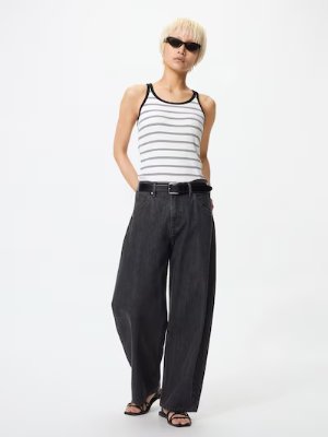 Model wearing women's baggy barrel-leg jeans shown full-length on a white background.