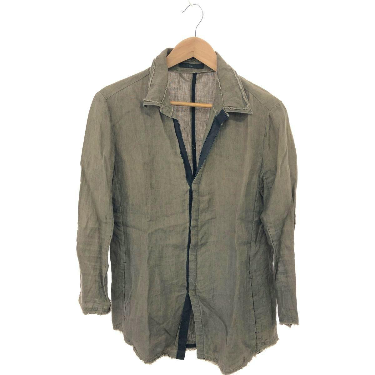 Brown bajra linen shirt jacket hanging on a wooden hanger against a white background.