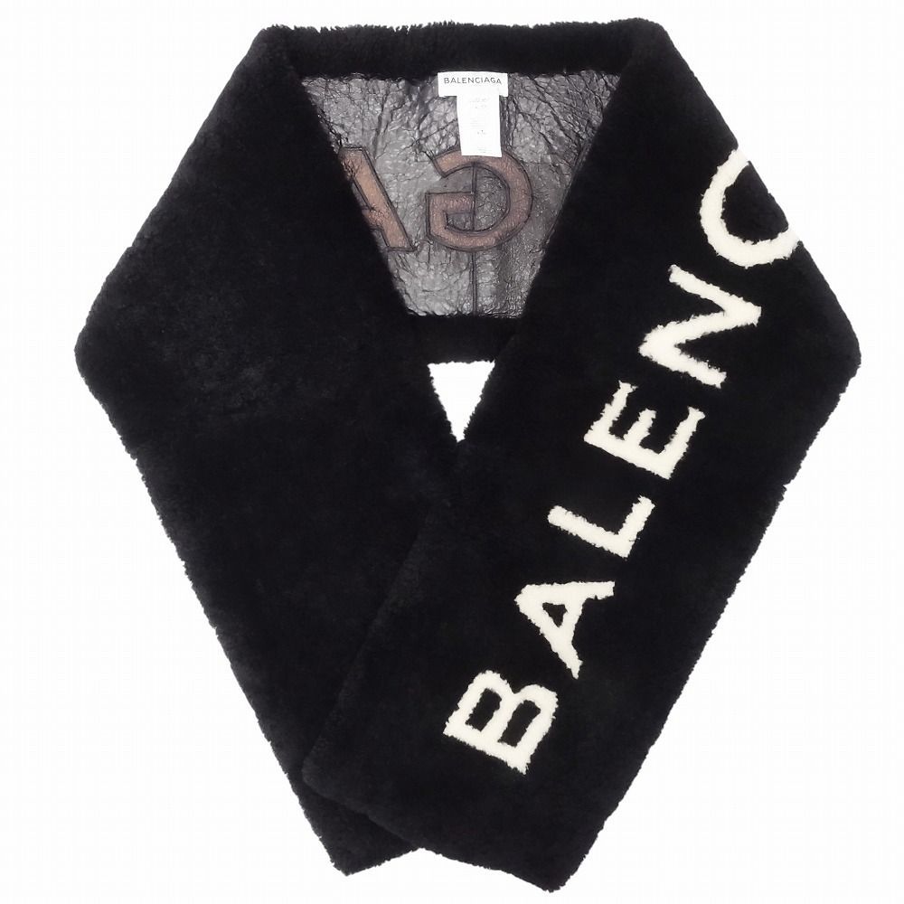 Black Balenciaga mouton scarf with white "BALENCIAGA" lettering, shown folded.