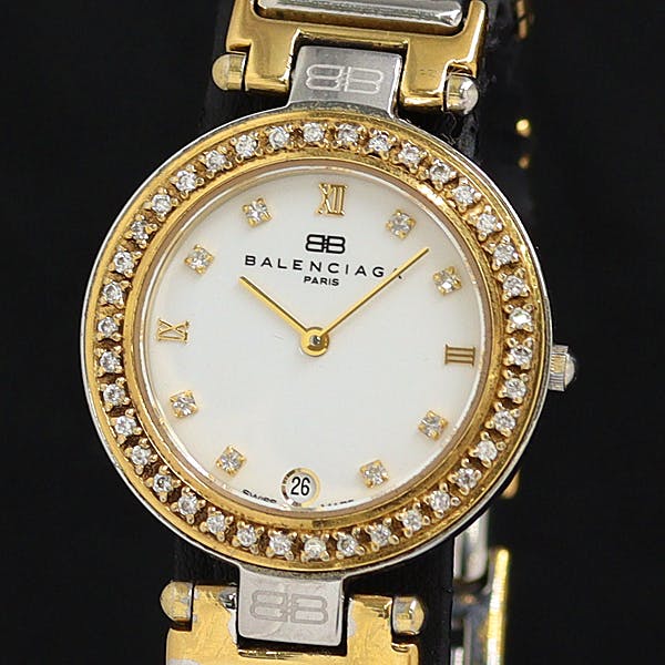 Front view of the Balenciaga women's watch showing a white dial, diamond bezel, gold-tone hands and markers, and a date window at 6 o'clock.