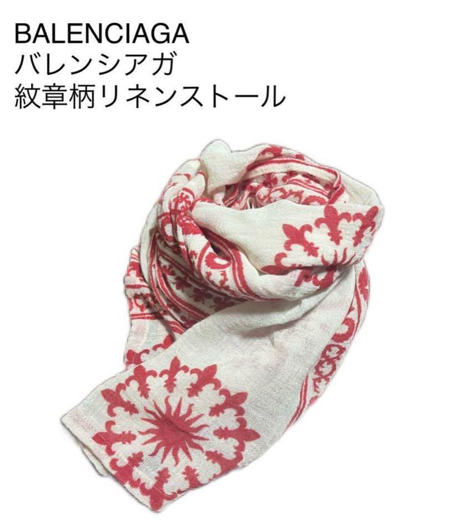A linen scarf with red emblem-like pattern arranged in a loose fold on a white background.