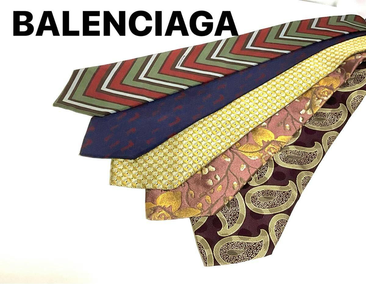Five neckties fanned on a white background showing different patterned designs with BALENCIAGA text above.