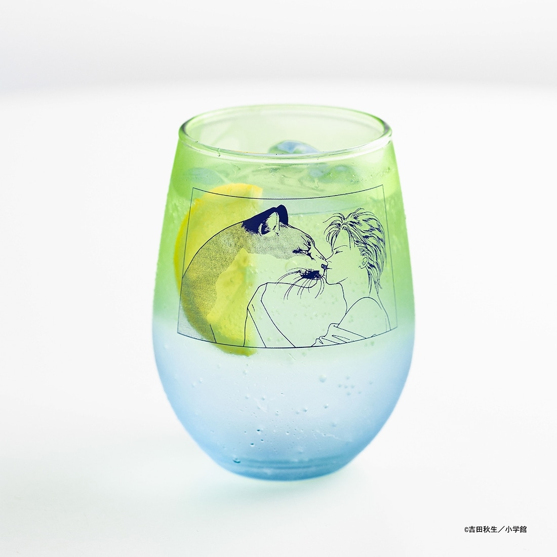 A drinking glass with a green-to-blue gradient and a printed line-art illustration of a person and an animal on the side.