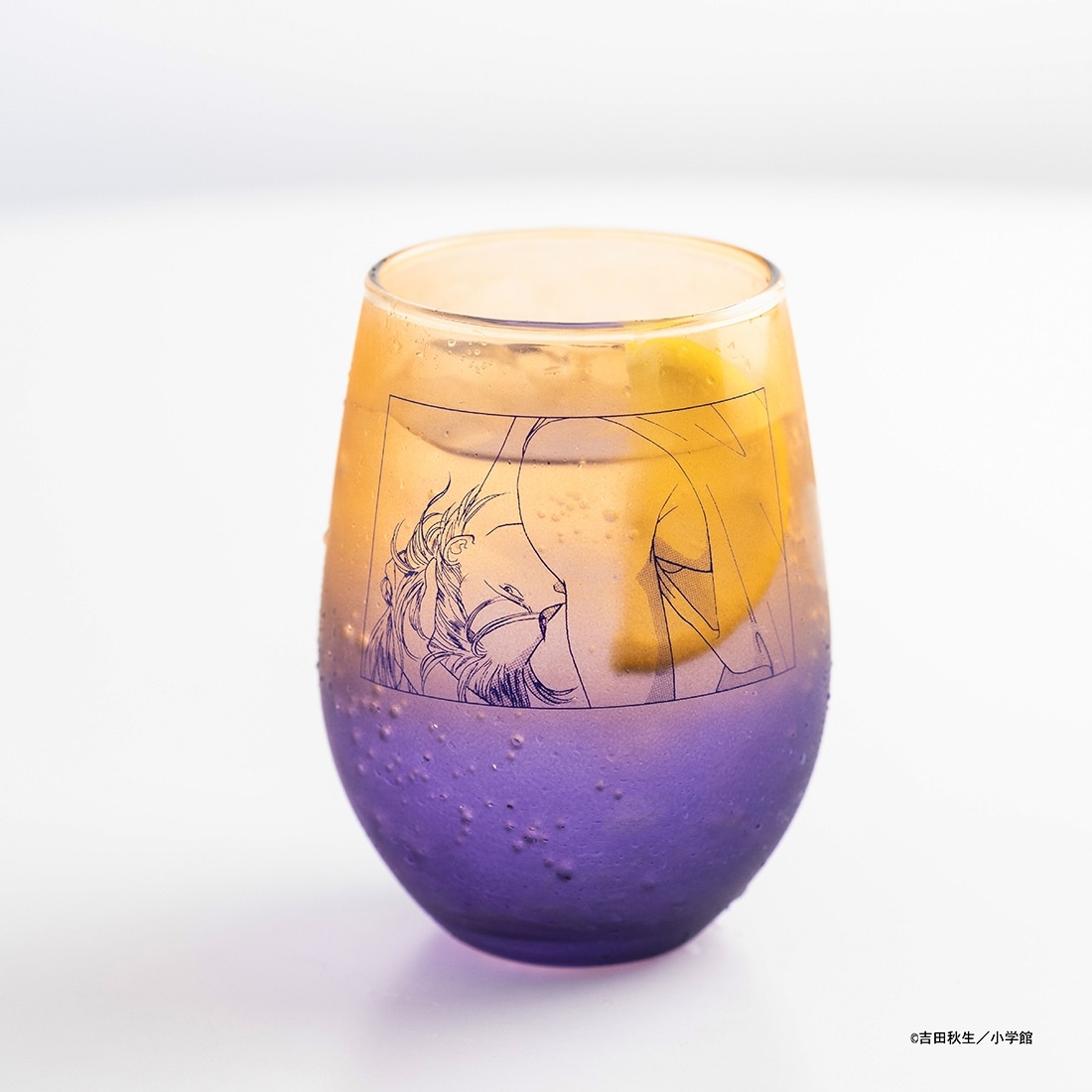 A gradient purple-to-amber drinking glass featuring line-art BANANA FISH character illustration.