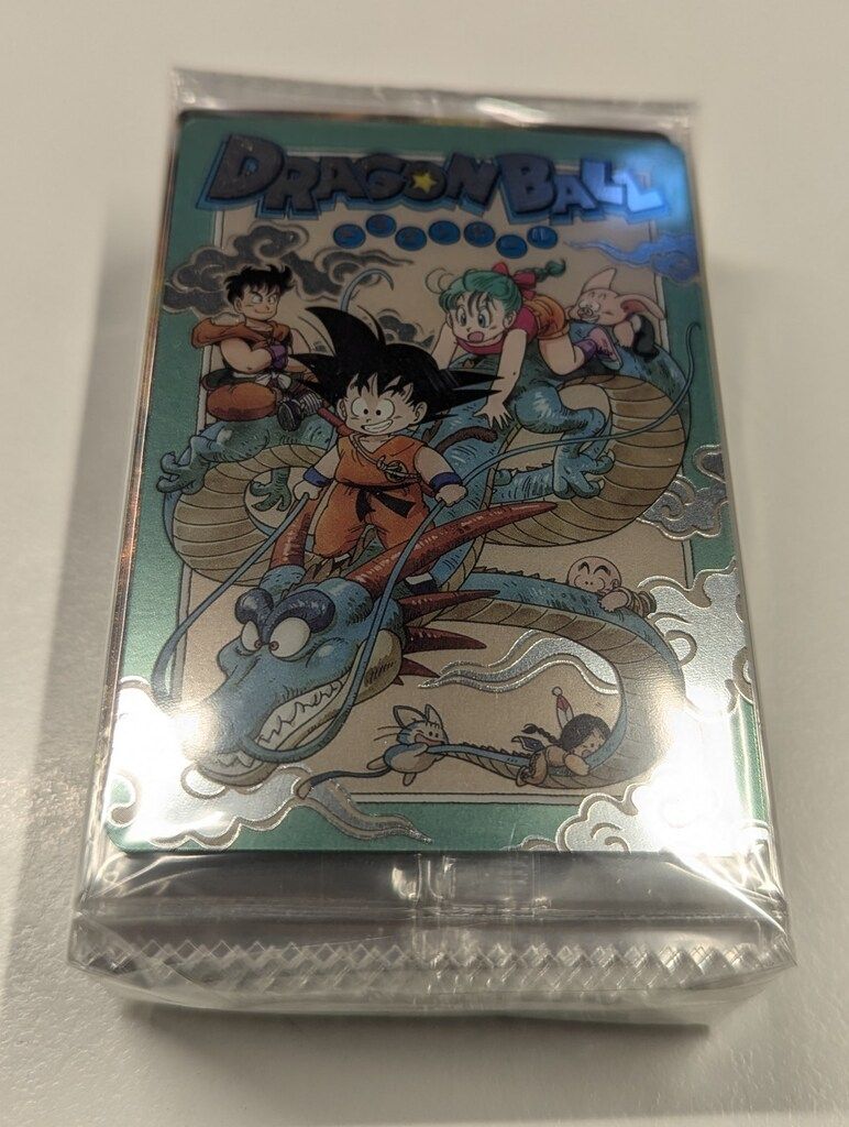 Sealed stack of Dragon Ball photocards showing young Goku and other characters on a reflective card front.